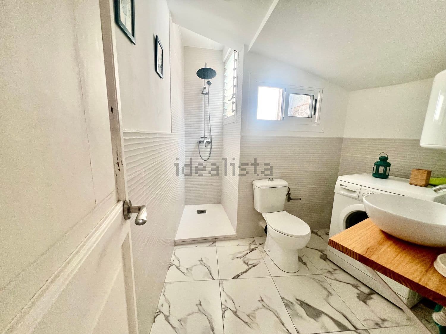 Vista del baño desde la puerta, con la ducha al fondo