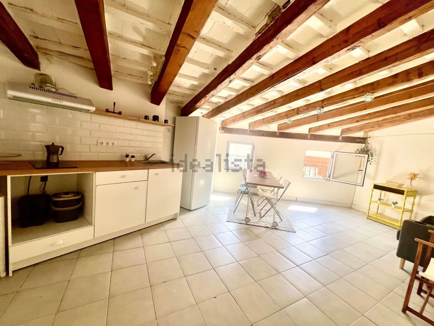Cocina equipada con frigorífico bajo las vigas de madera