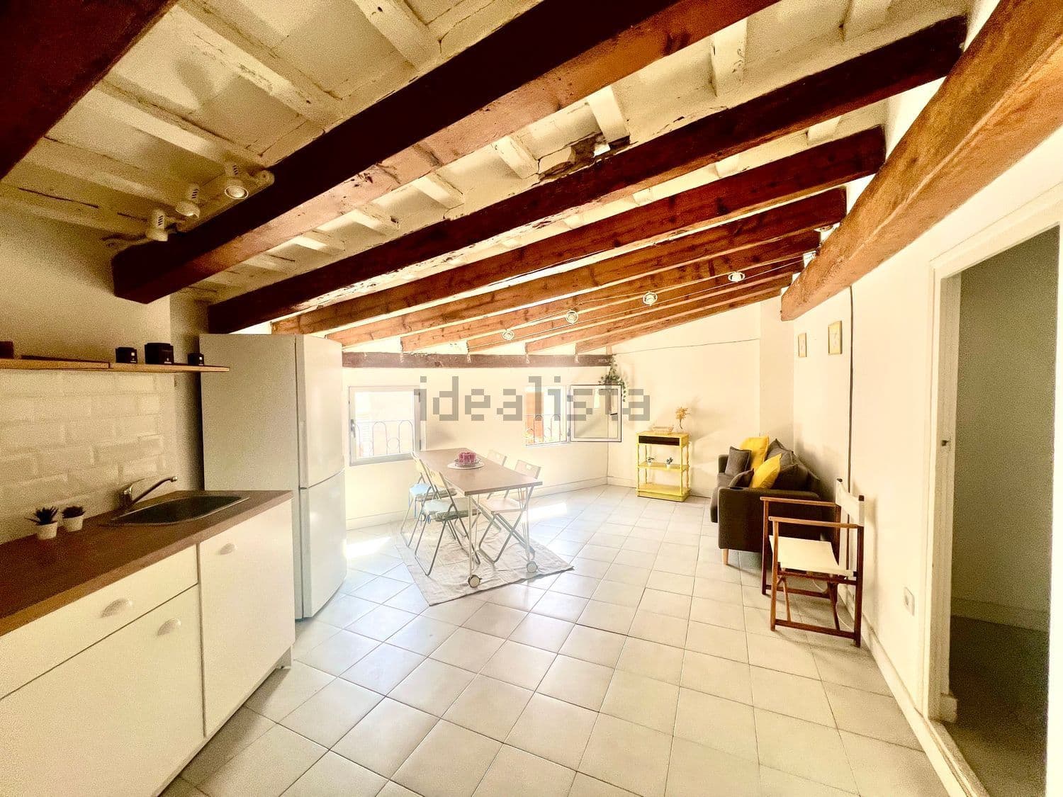 Cocina y salón en un mismo espacio con vigas de madera