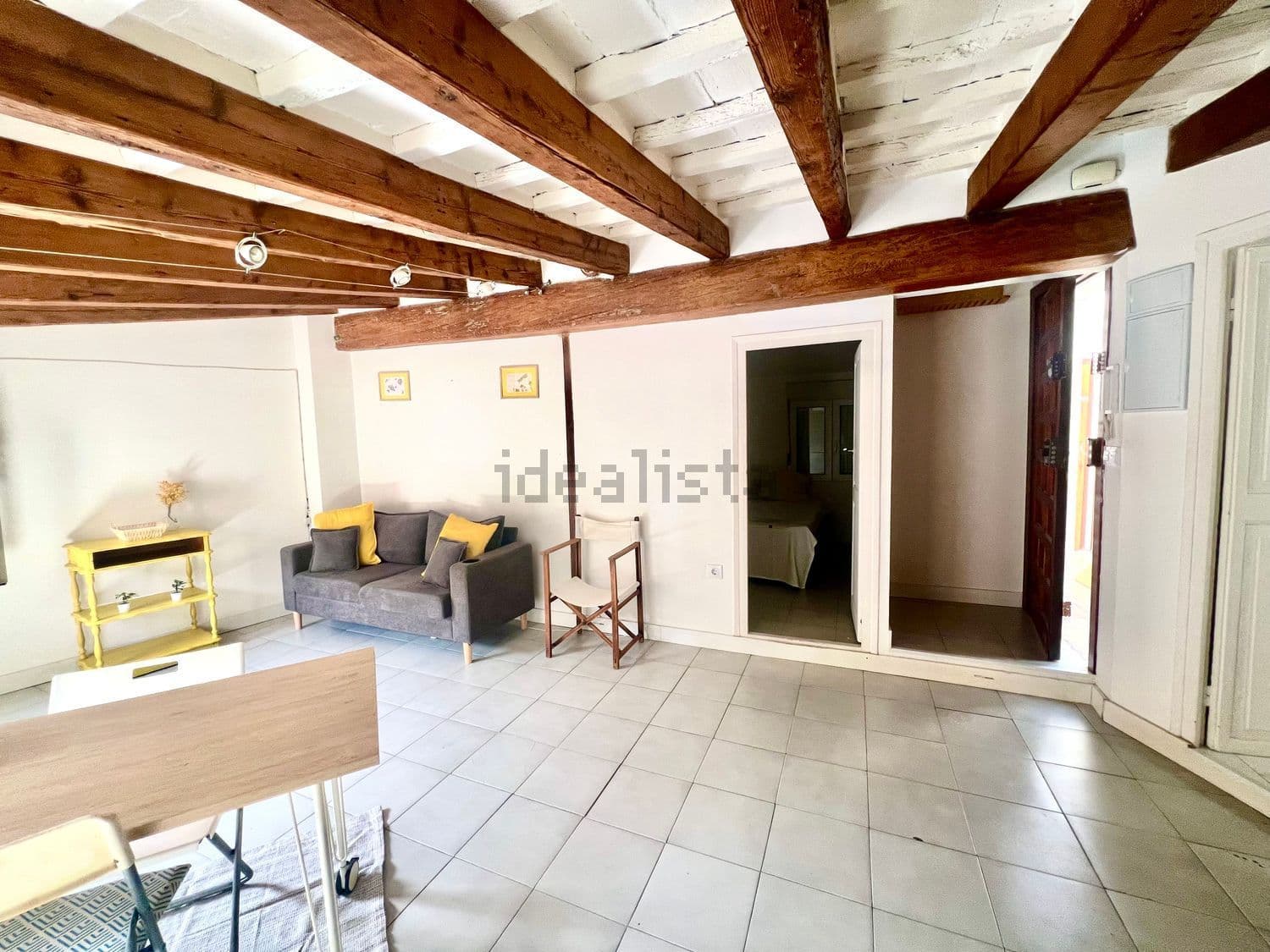 Salón con sofá gris y las puertas del dormitorio y del baño