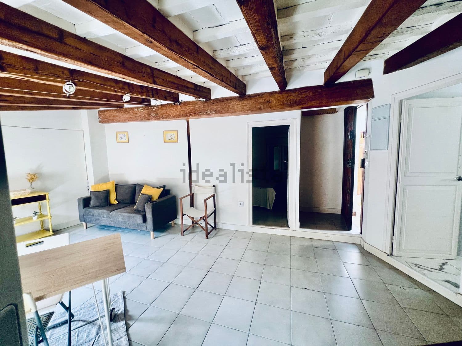 Salón con sofá y vigas de madera vistas