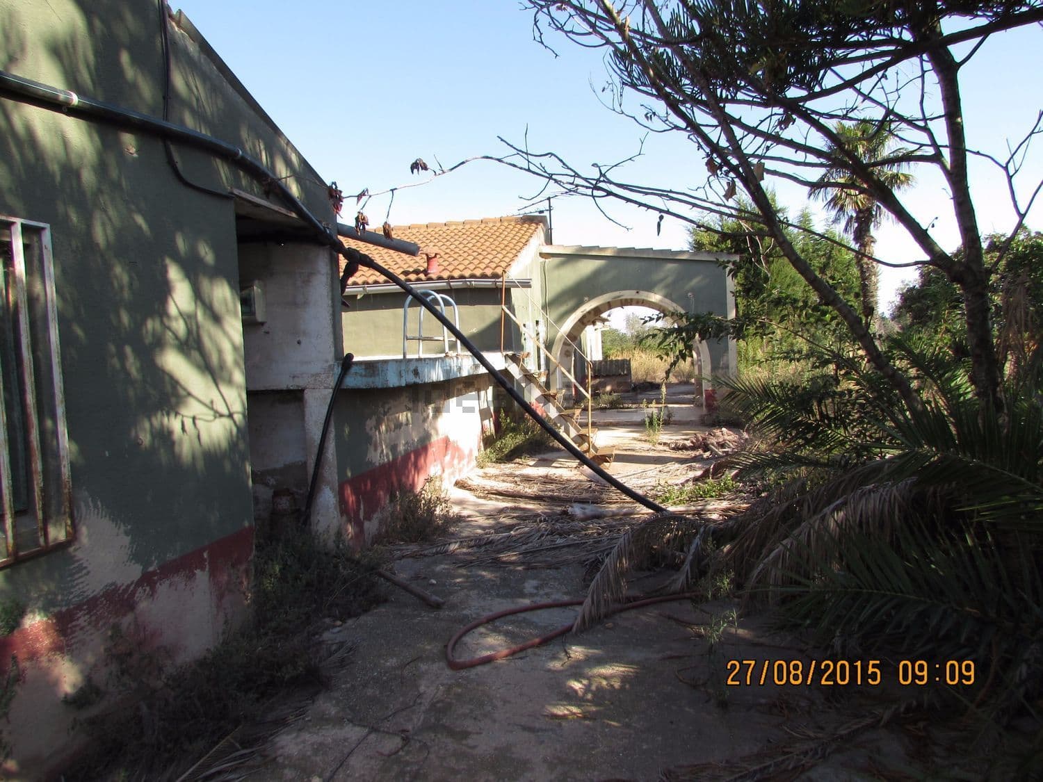 Exterior de la casa con el camino de acceso y vegetación