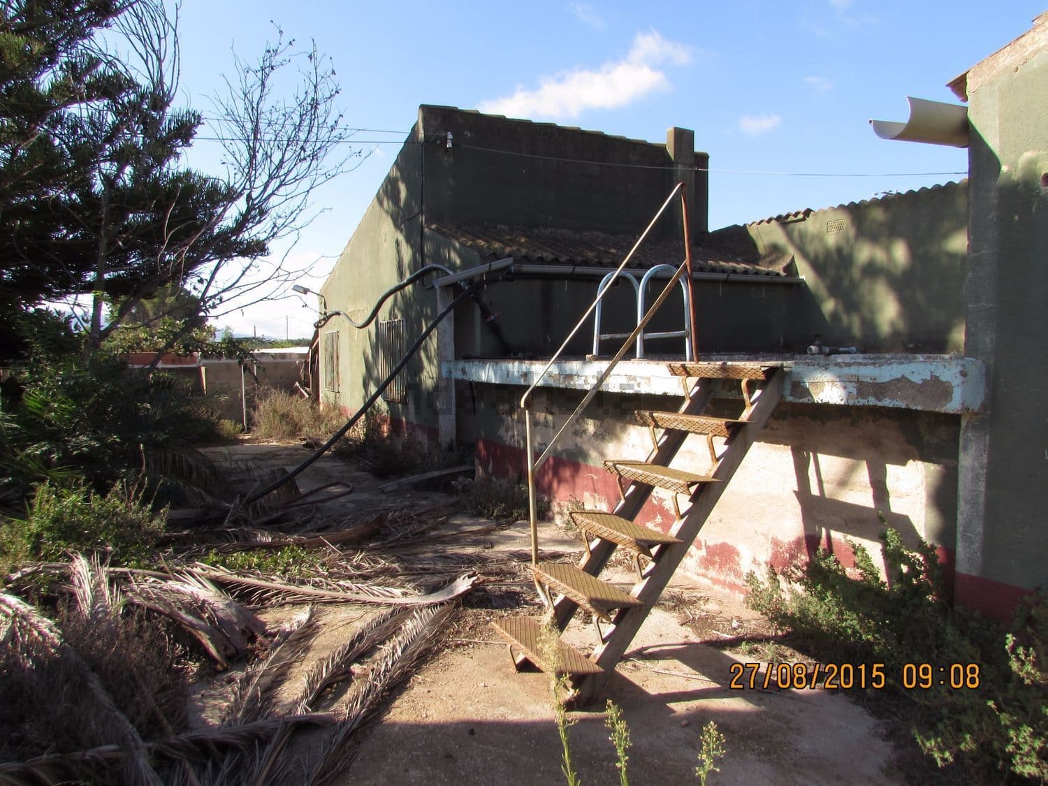 Parte trasera de la casa con escalera exterior metálica