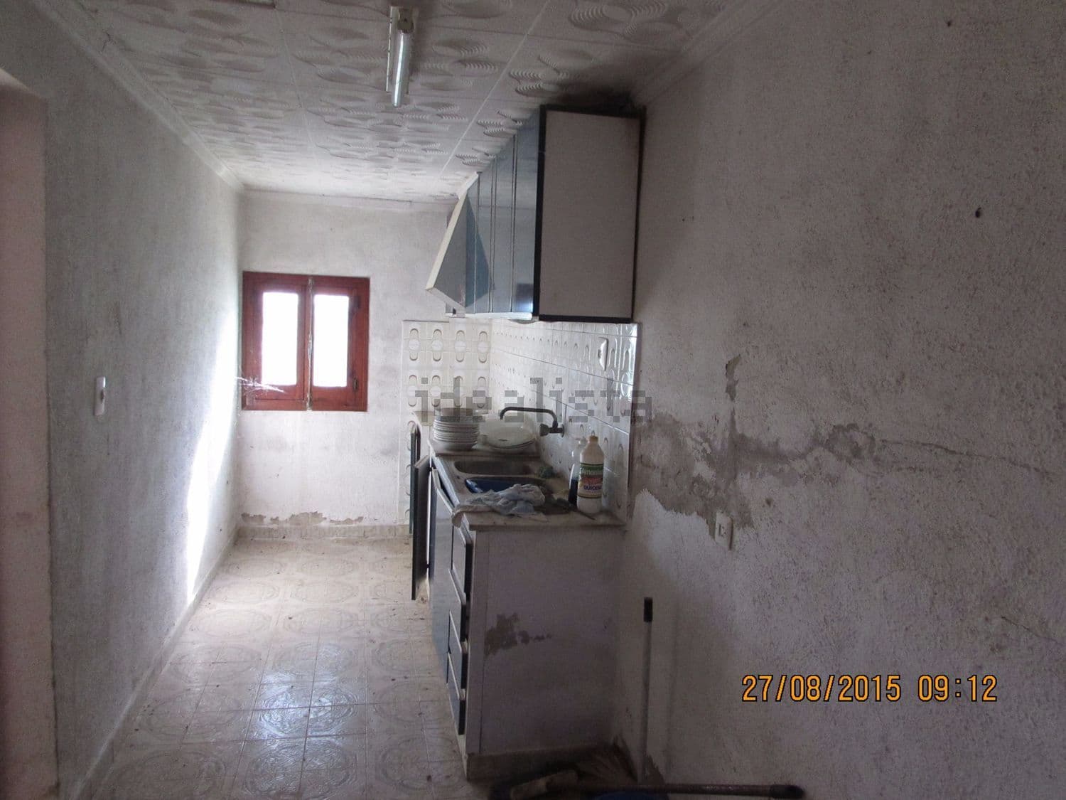 Cocina alargada con muebles y ventana al fondo