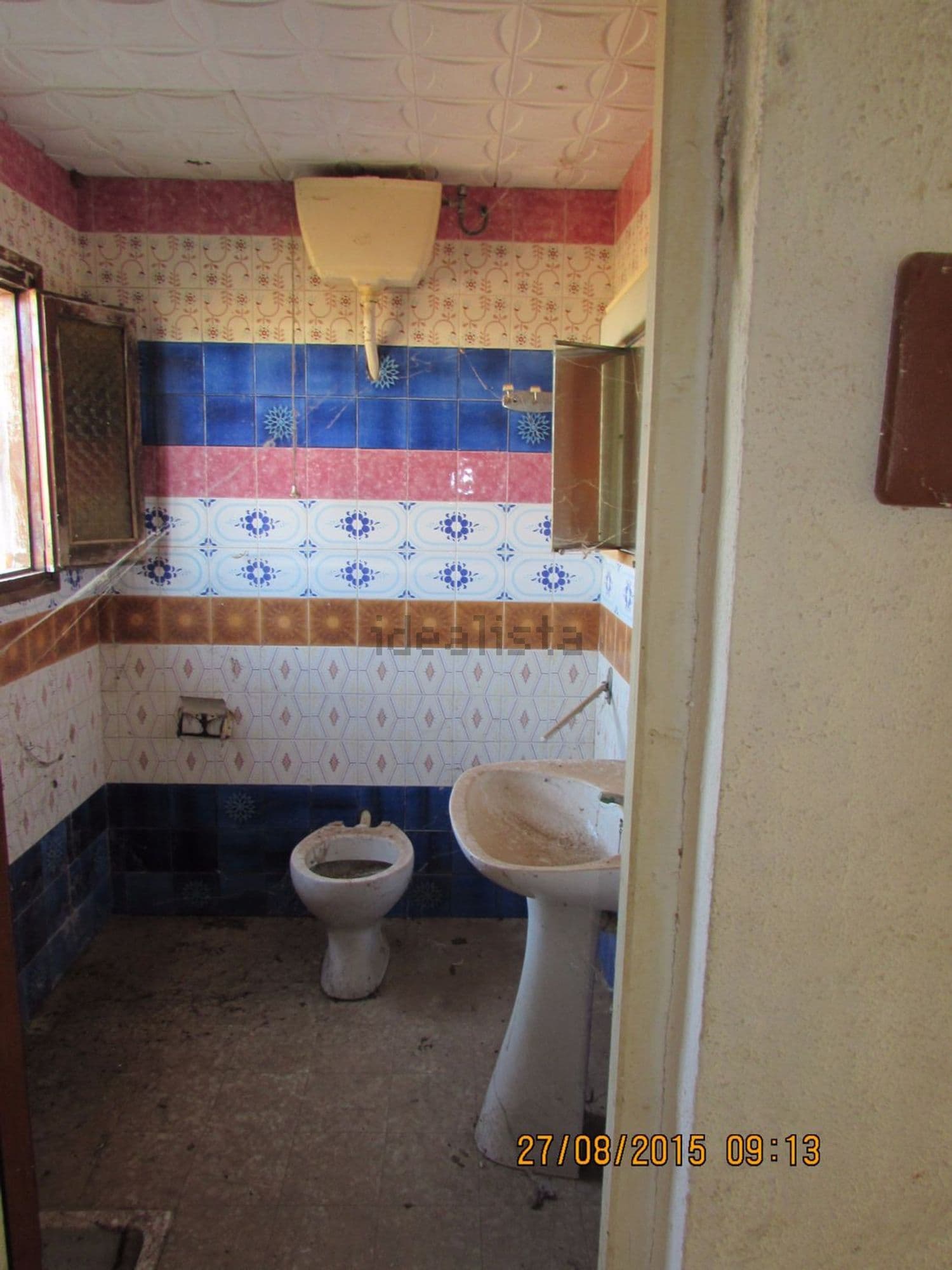 Baño con inodoro, lavabo y azulejos de colores