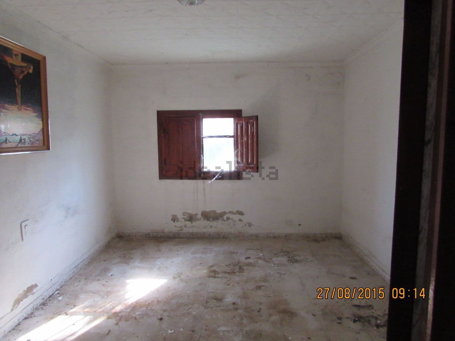 Dormitorio vacío con ventana de madera