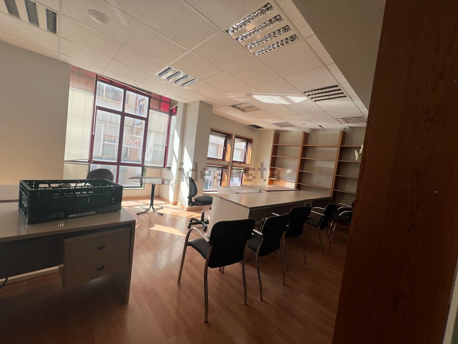 Sala de trabajo con mesas, sillas y ventanales