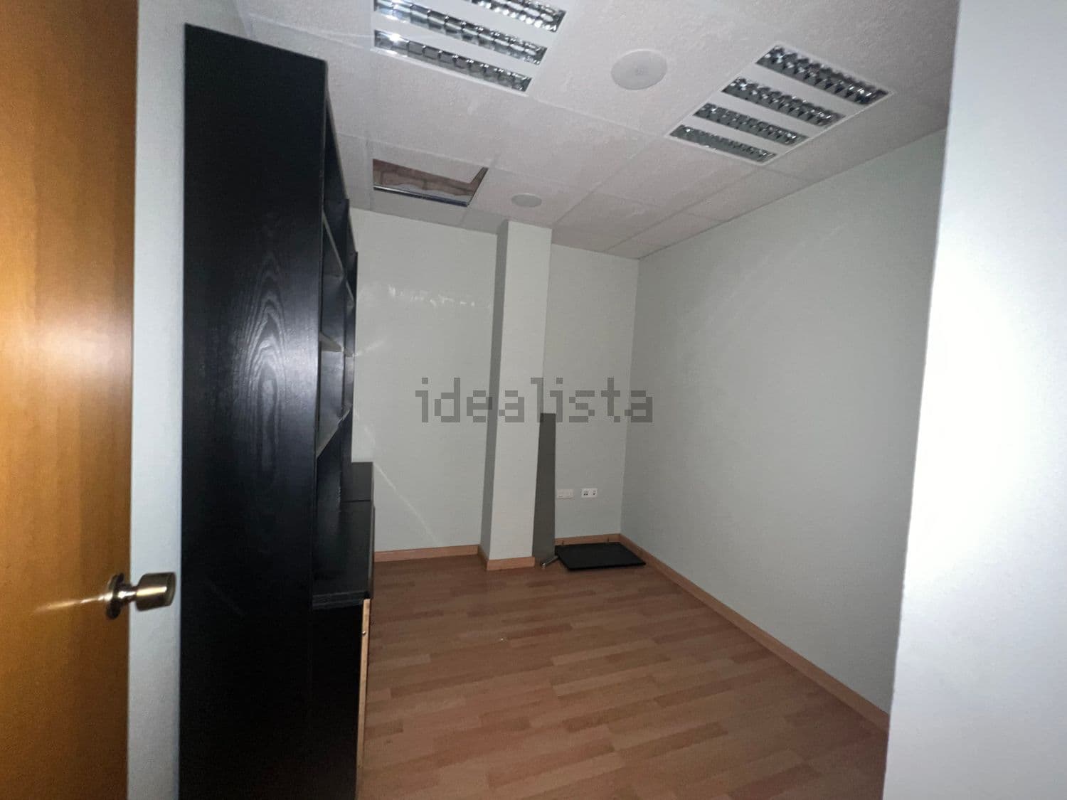 Estancia con estantería oscura y suelo de madera