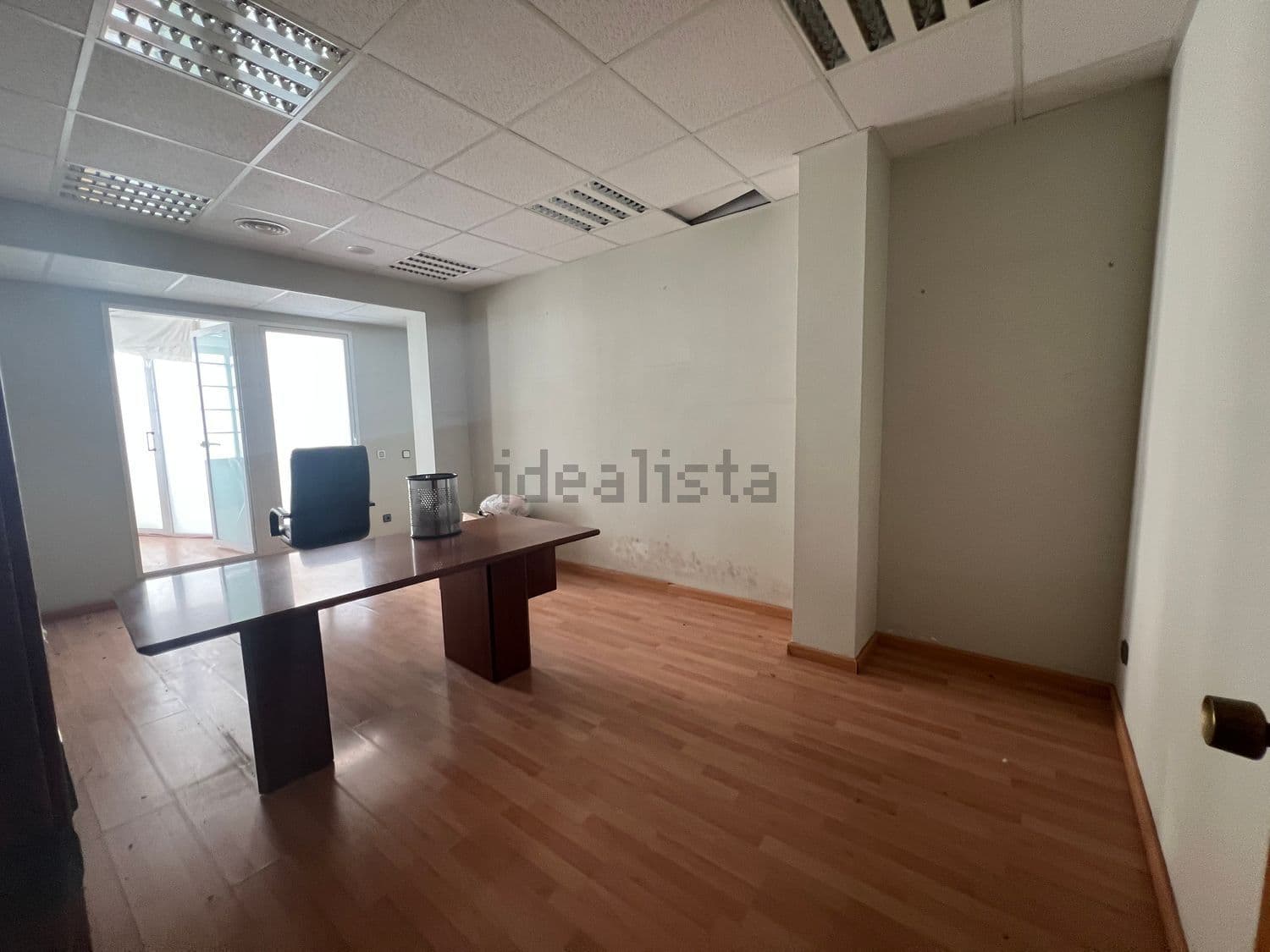 Despacho con mesa y puerta acristalada al fondo
