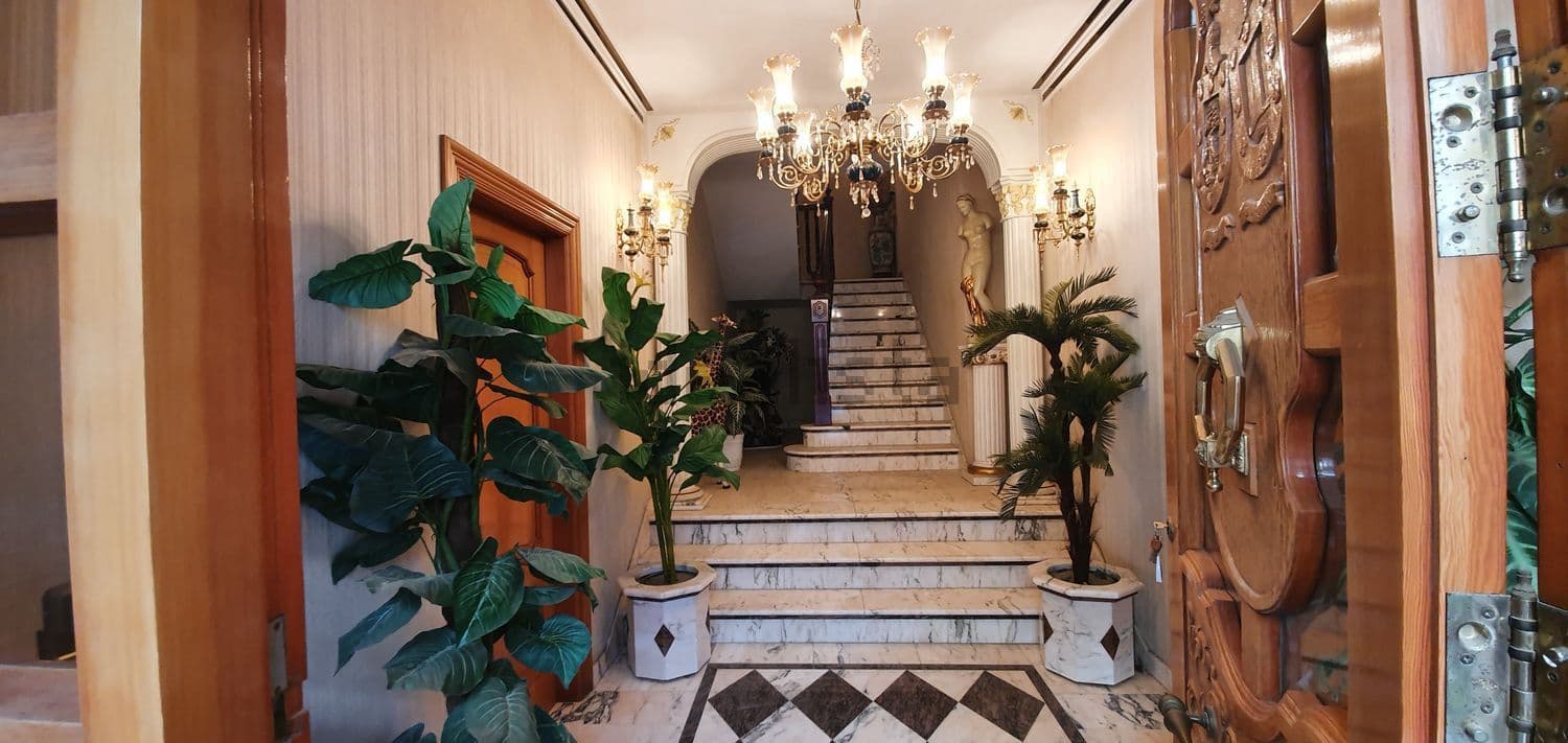 Recibidor con escalera de mármol y plantas