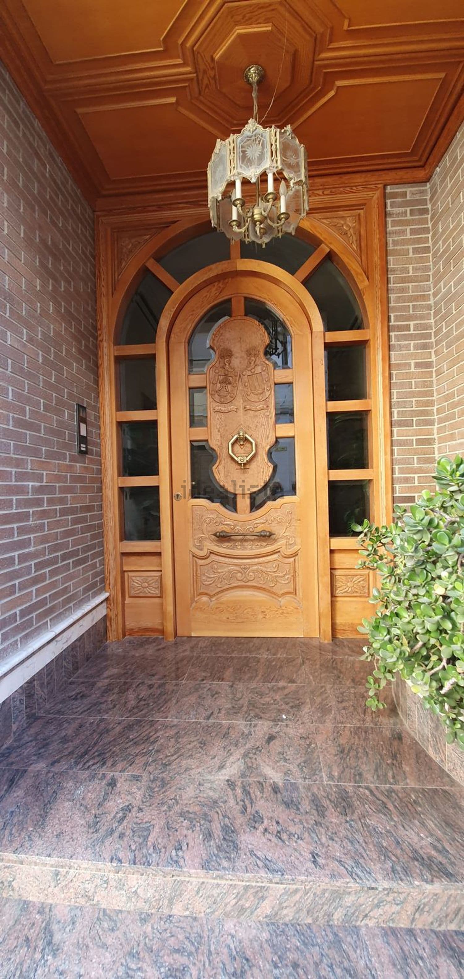 Puerta de madera con vidriera en el porche de entrada