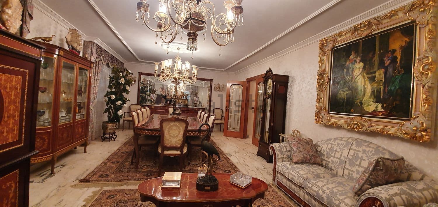 Salón comedor con sofá, vitrinas y un gran cuadro