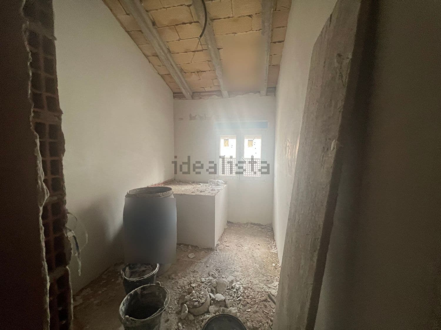 Estancia en obra bajo cubierta con ventana pequeña
