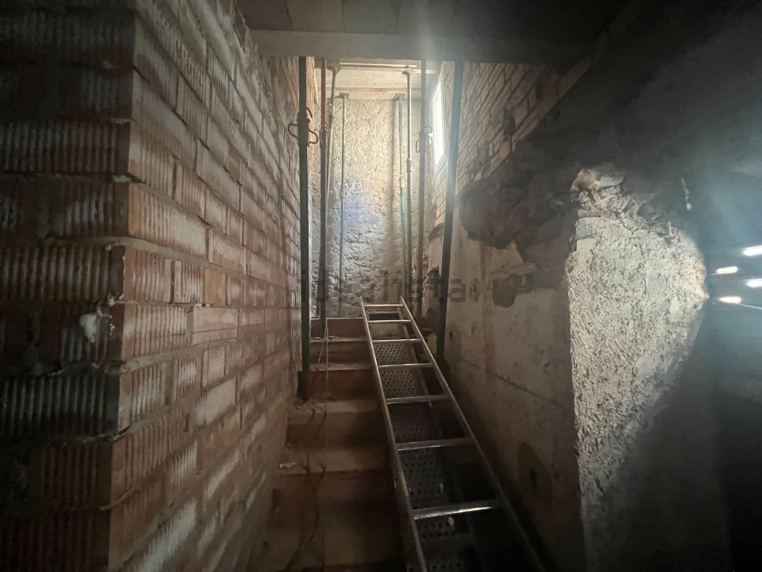 Hueco de escalera en obra con una escalera de mano