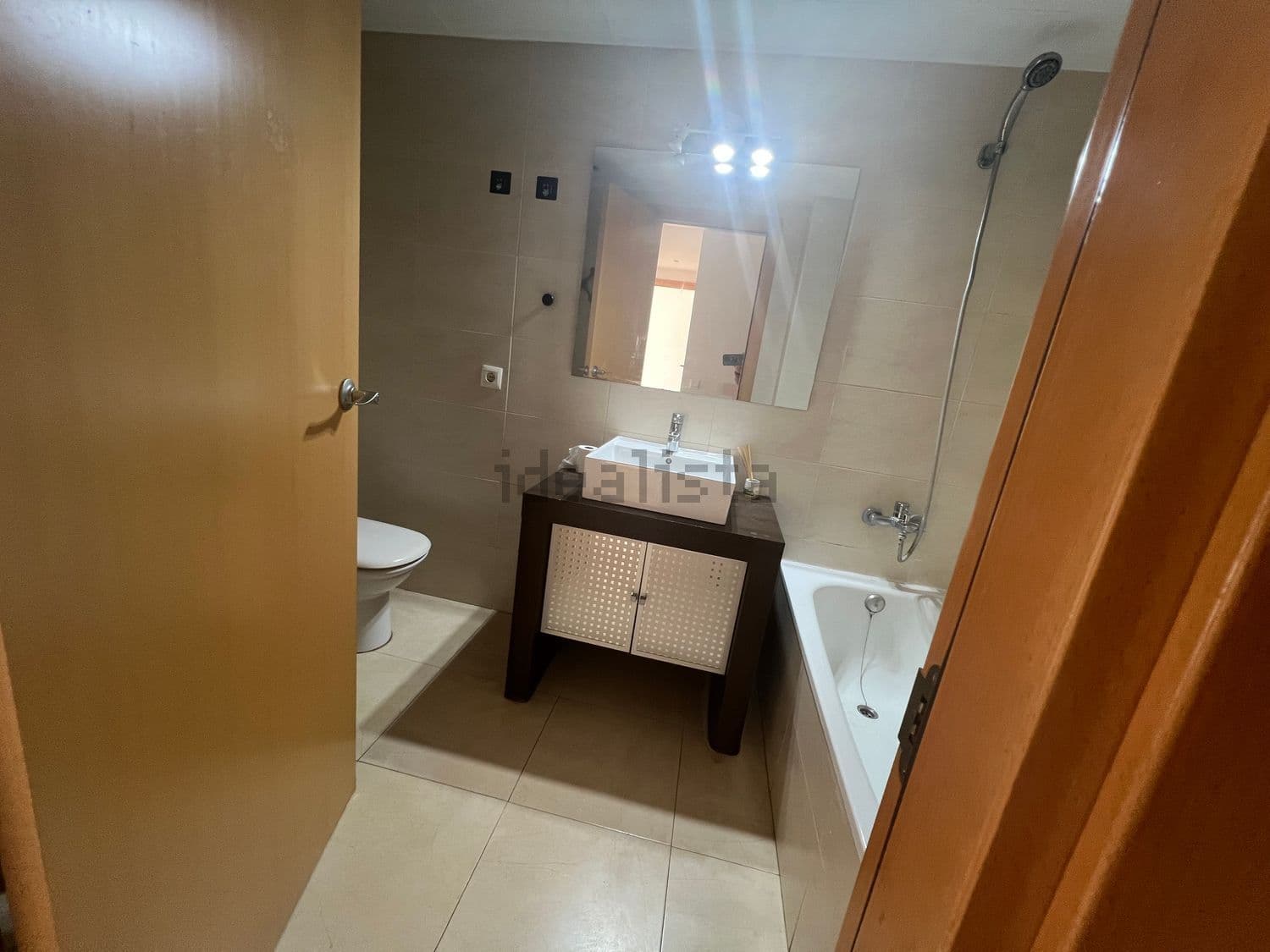 Baño con bañera, inodoro y mueble de lavabo