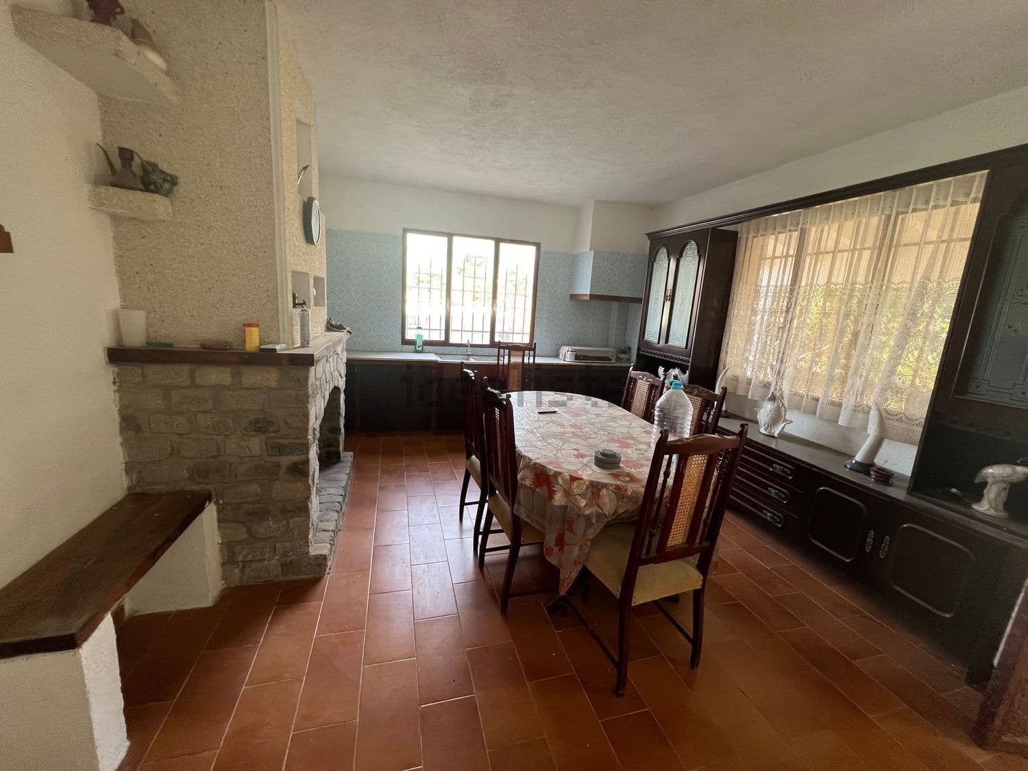 Cocina comedor con chimenea de piedra y mesa
