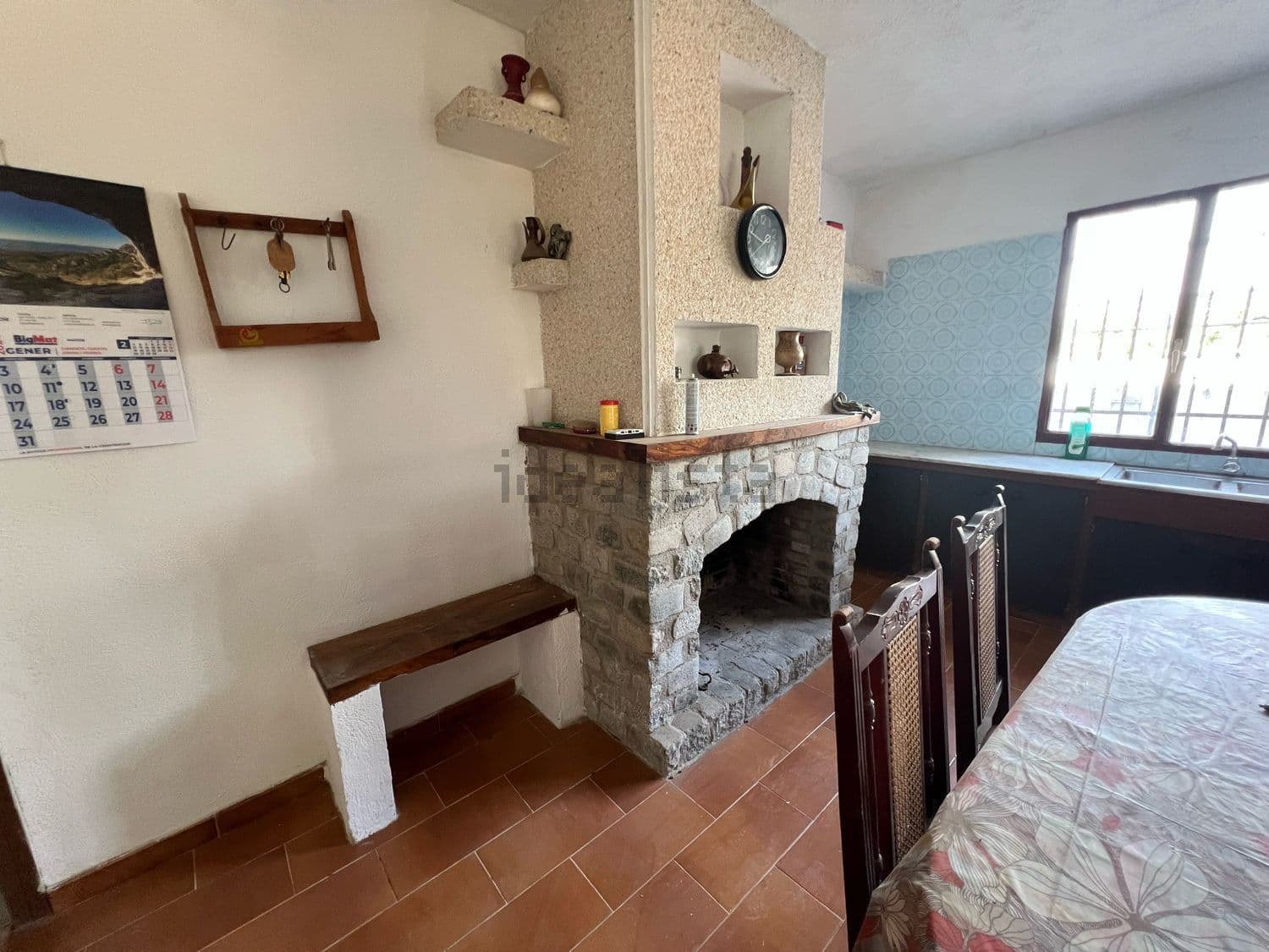 Chimenea de piedra con banco junto a la mesa del comedor