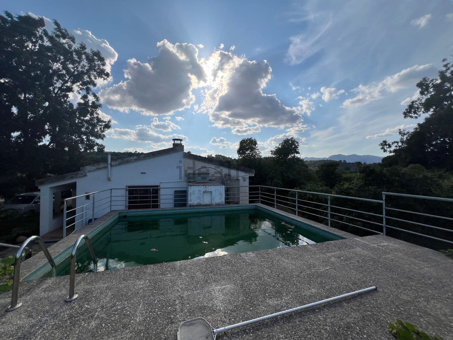 Piscina con la casa al fondo
