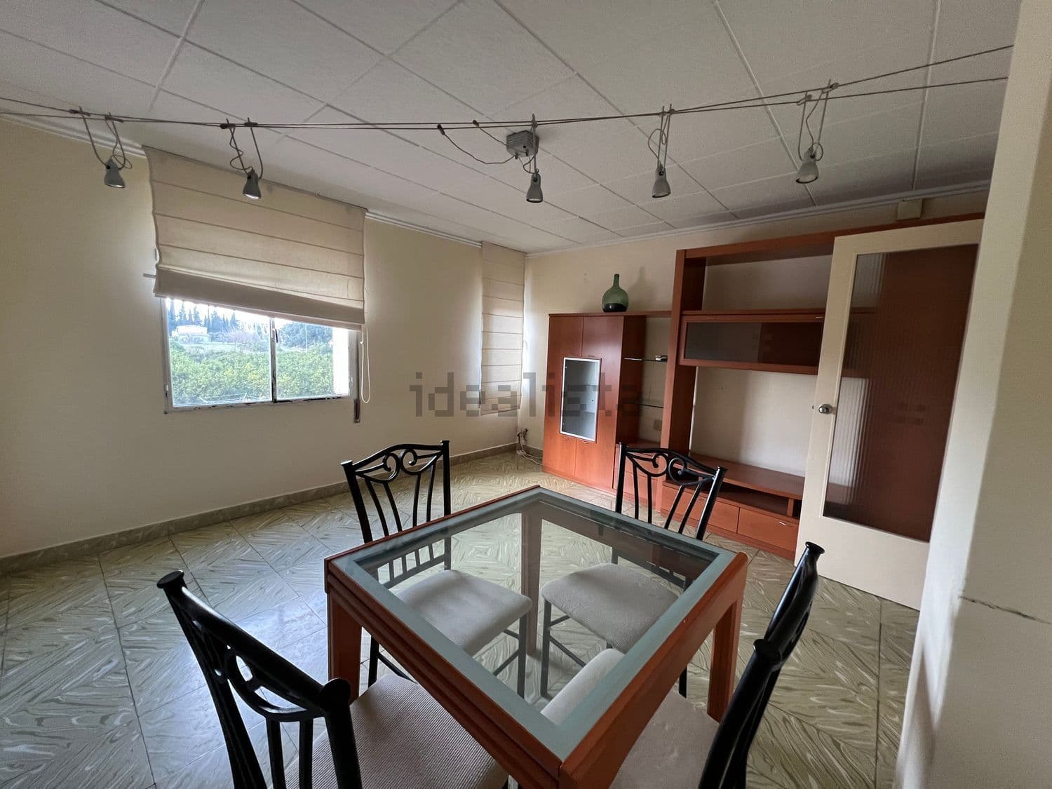 Comedor con mesa de cristal y estantería