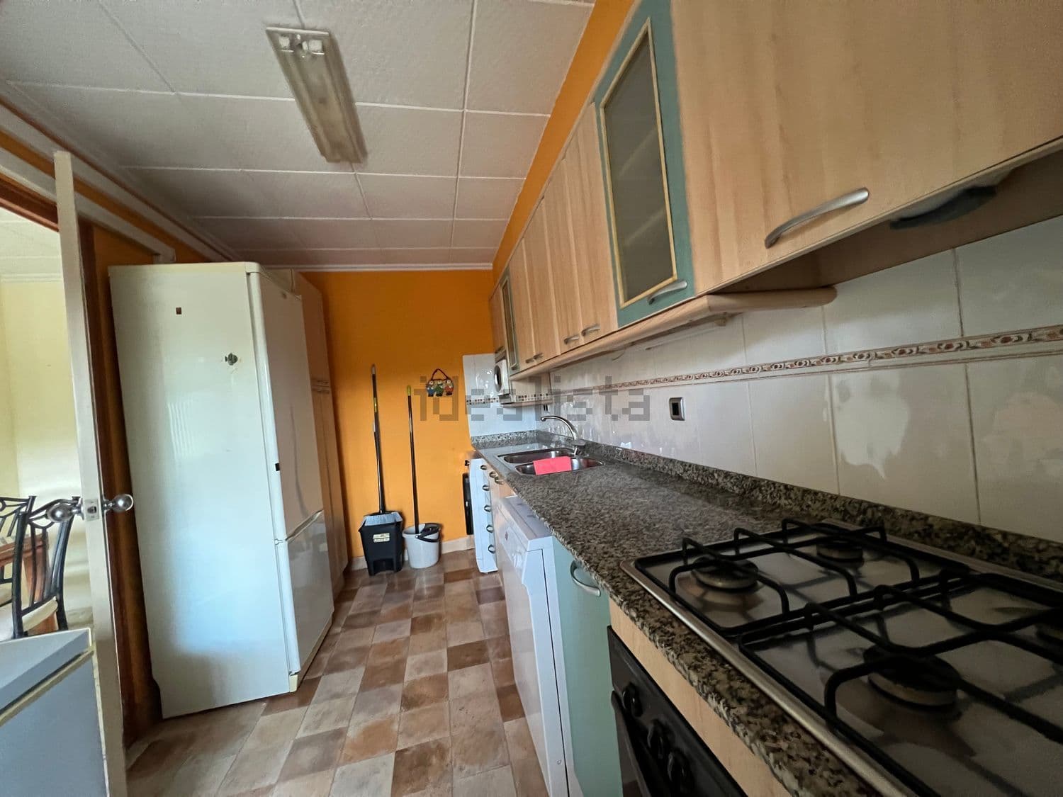 Cocina con placa de gas, horno y frigorífico