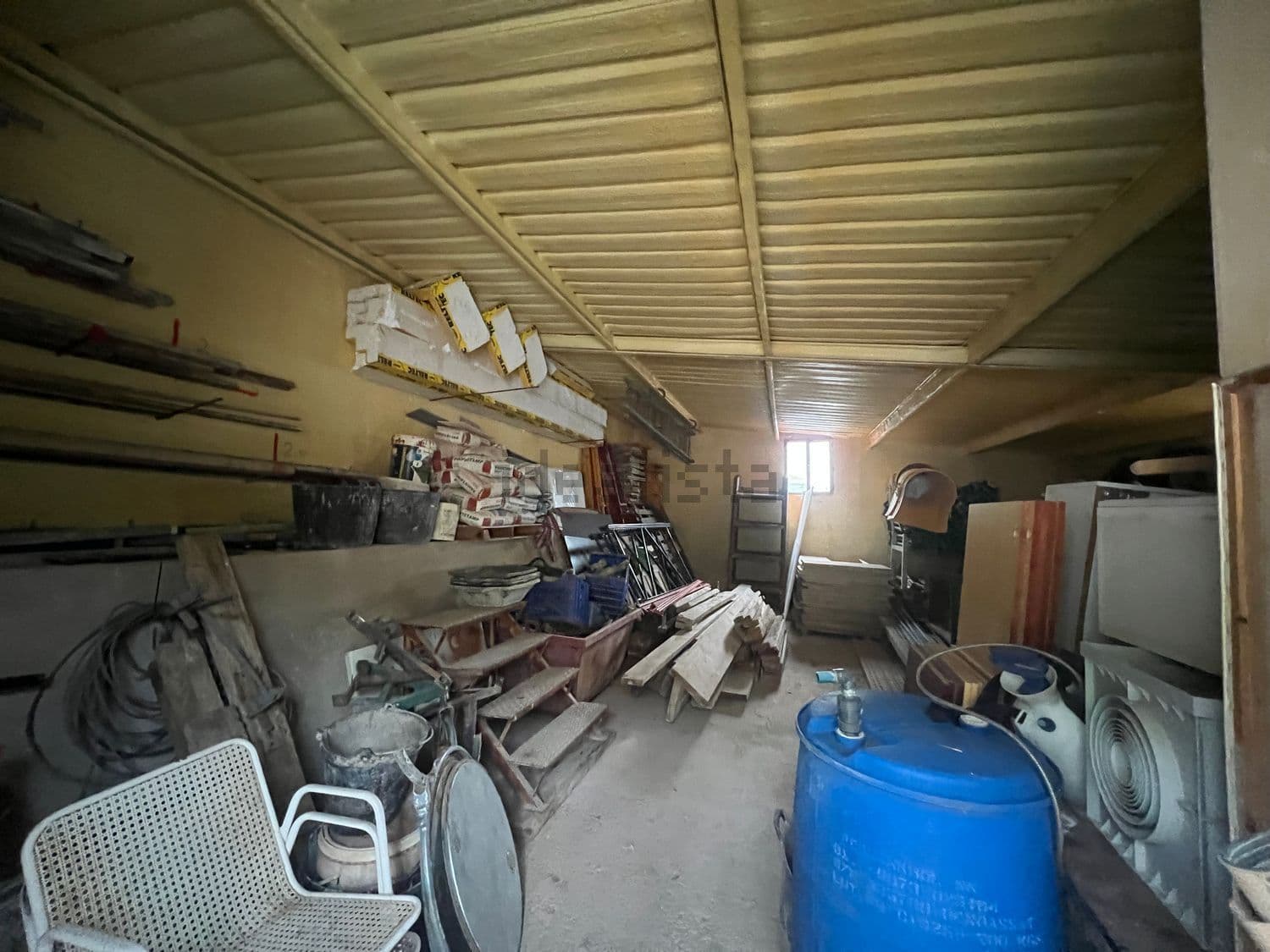 Interior del almacén con estanterías y enseres