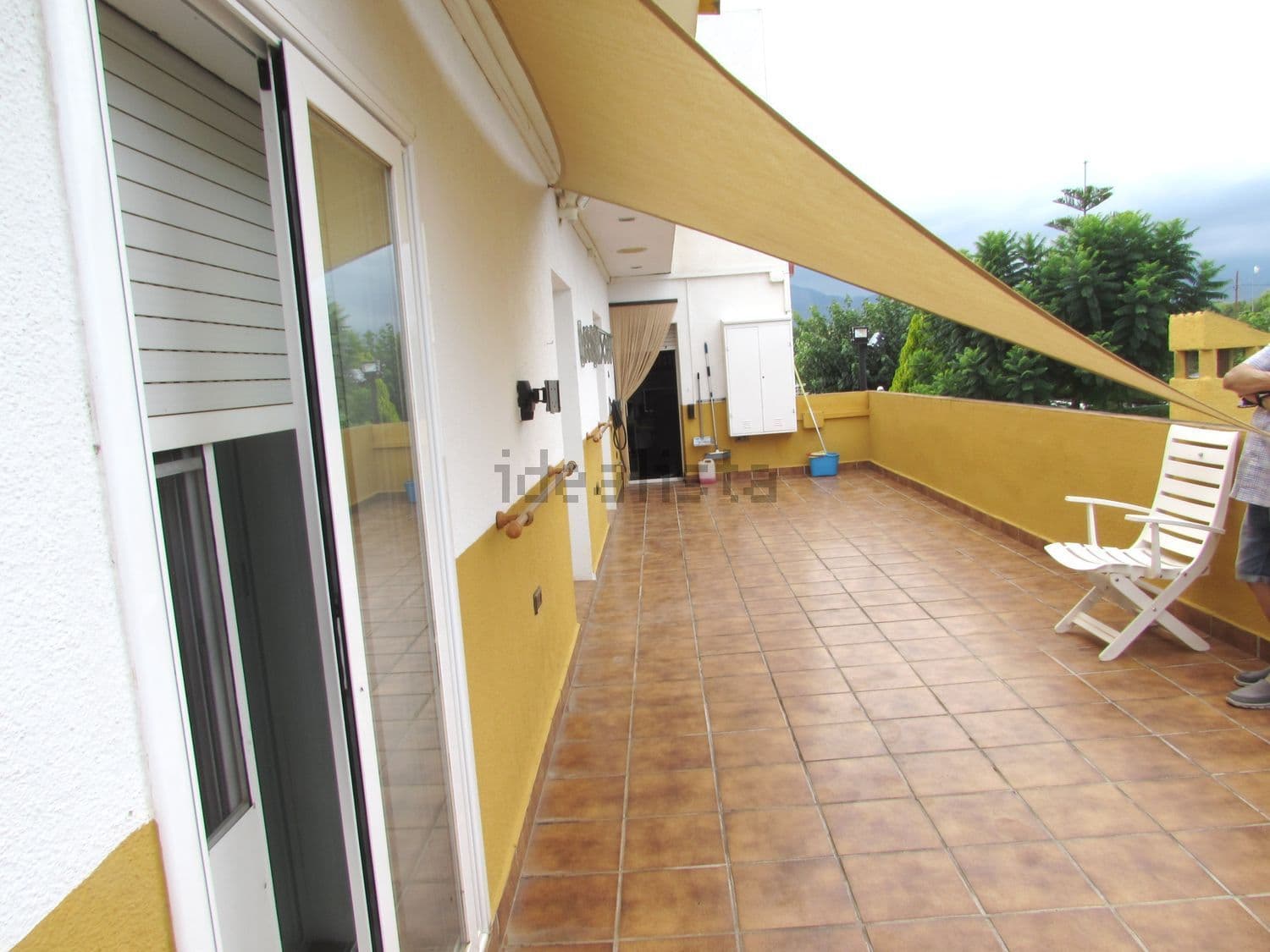 Terraza con toldo y sillas junto a la casa