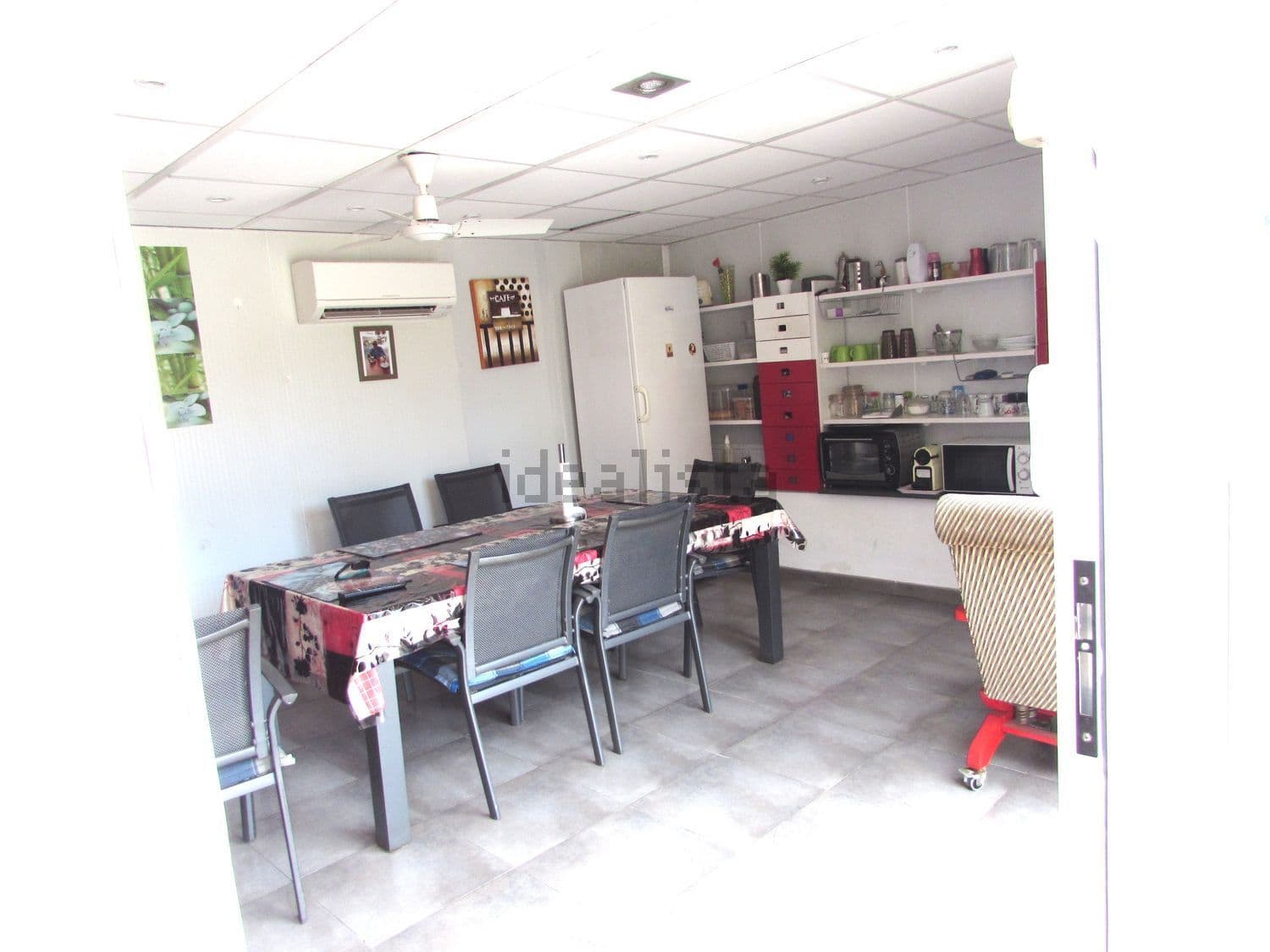 Cocina de verano con mesa, sillas y frigorífico
