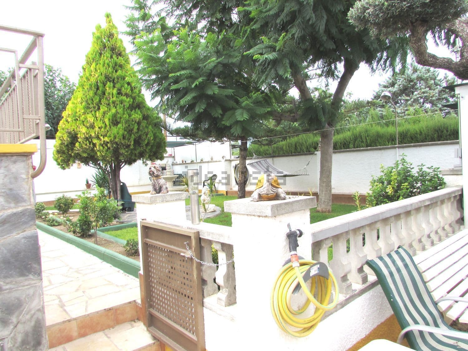 Jardín con césped, árboles y balaustrada