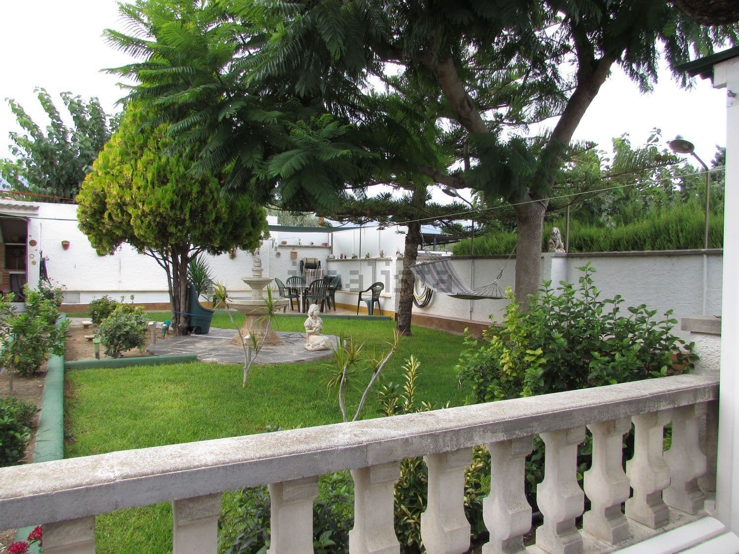 Jardín con césped y zona de estar al fondo