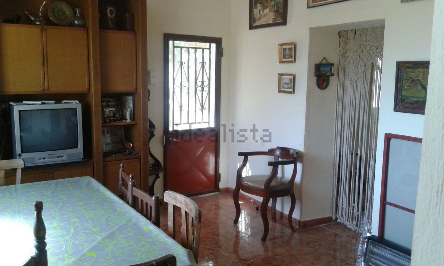 Comedor con mesa, televisor y puerta de entrada