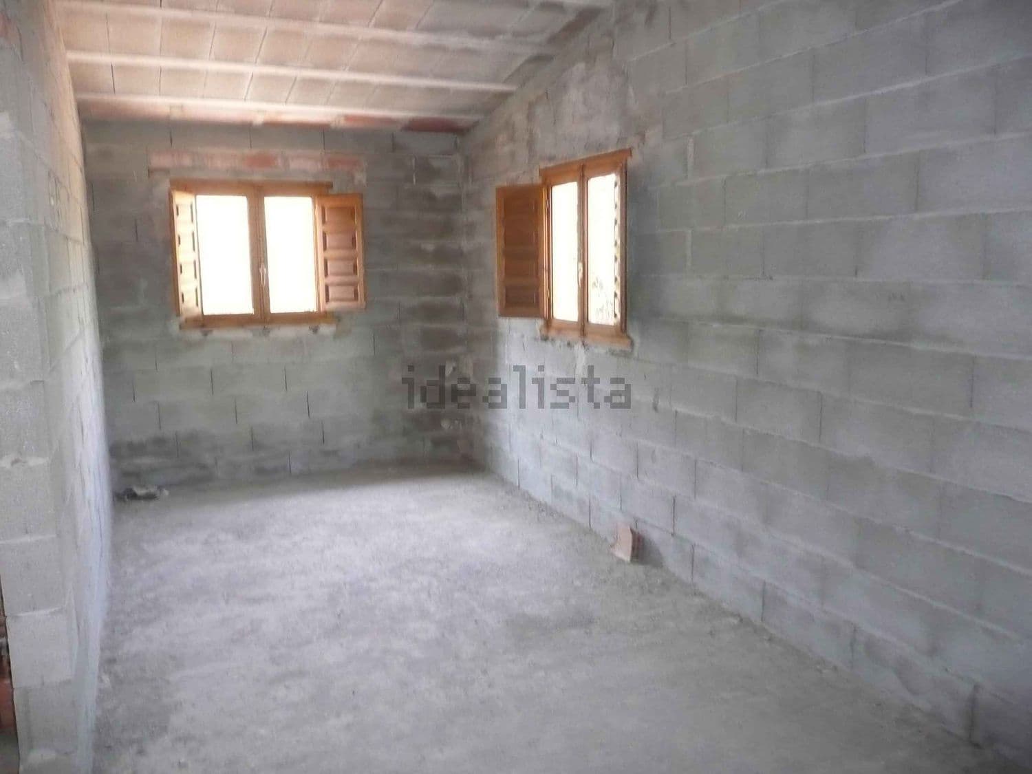 Interior de la casa por terminar, con ventanas de madera