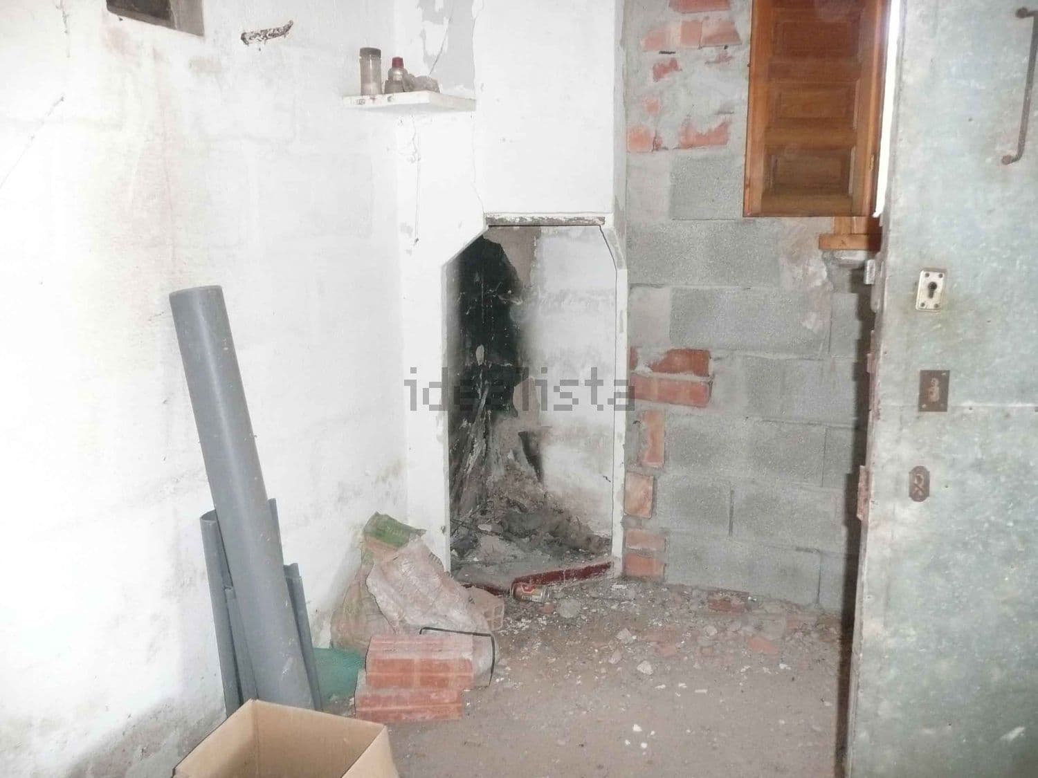Estancia interior en obra con chimenea