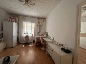 Salón con escritorio, cómoda y ventana