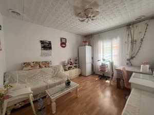 Salón con sofá y frigorífico junto a la ventana