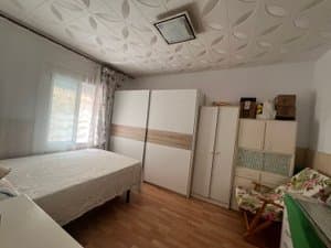 Dormitorio con cama y armarios blancos