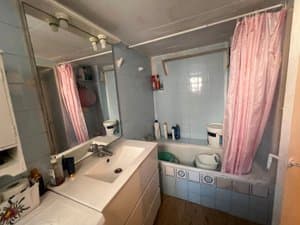 Baño con bañera, cortina y mueble de lavabo