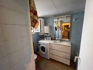 Espacio con lavadora, lavabo y termo