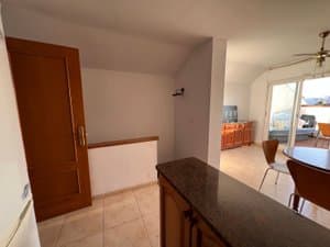 Entrada con barra de cocina y escalera