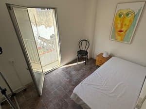 Habitación con cama y puerta abierta al balcón