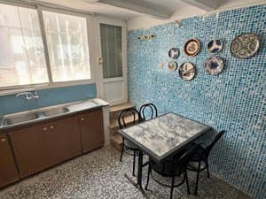 Cocina comedor con mesa y pared de mosaico azul