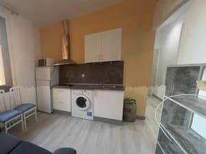 Cocina con lavadora, frigorífico y campana