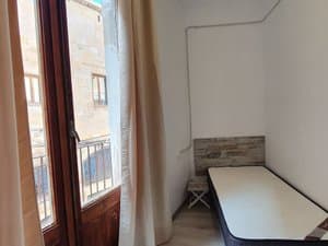 Dormitorio con cama individual y puerta balconera