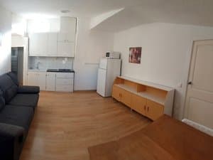 Salón con sofá y cocina abierta al fondo
