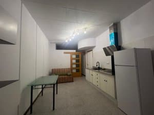 Espacio diáfano con cocina, frigorífico y mesa
