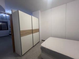 Zona con armario de puertas correderas y cama
