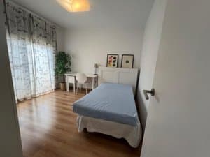 Dormitorio con cama, escritorio y ventana