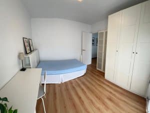 Dormitorio con cama, escritorio y armario blanco