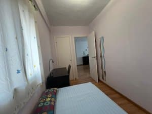 Dormitorio con cama y escritorio junto a la ventana