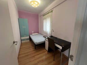 Dormitorio con cama individual, armario y escritorio