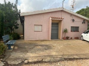 Fachada rosa de la casa con puerta de garaje